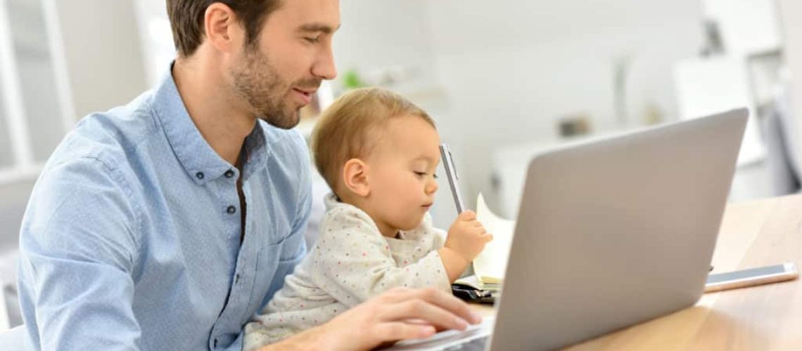 Busy businessman working from home and watching baby